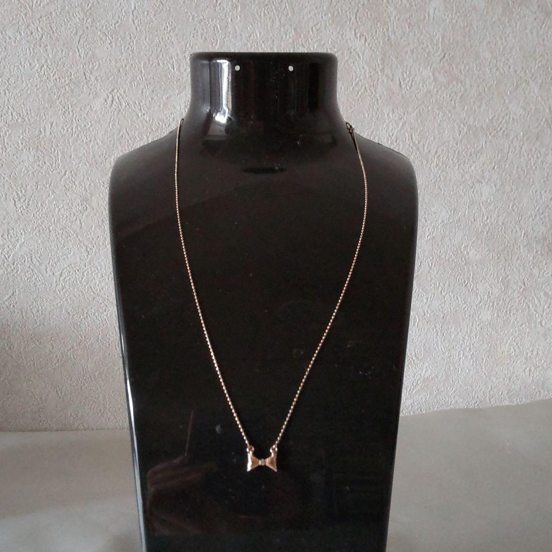 Beautiful agete ribbon-shaped necklace made of pink gold displayed on a white background