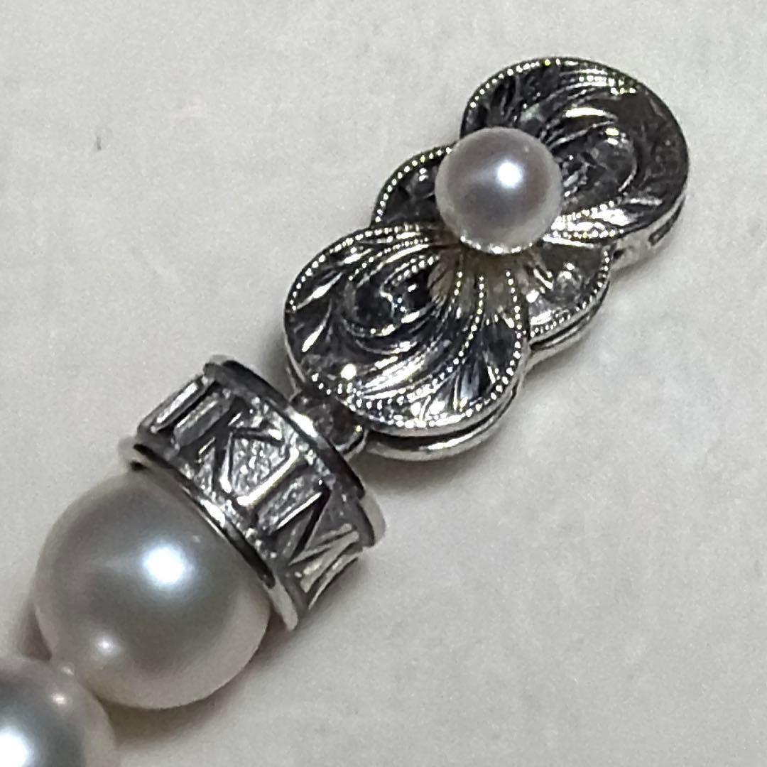 MIKIMOTO Akoya Pearl Necklace with 7.5 natural pearls and high luster on a white background