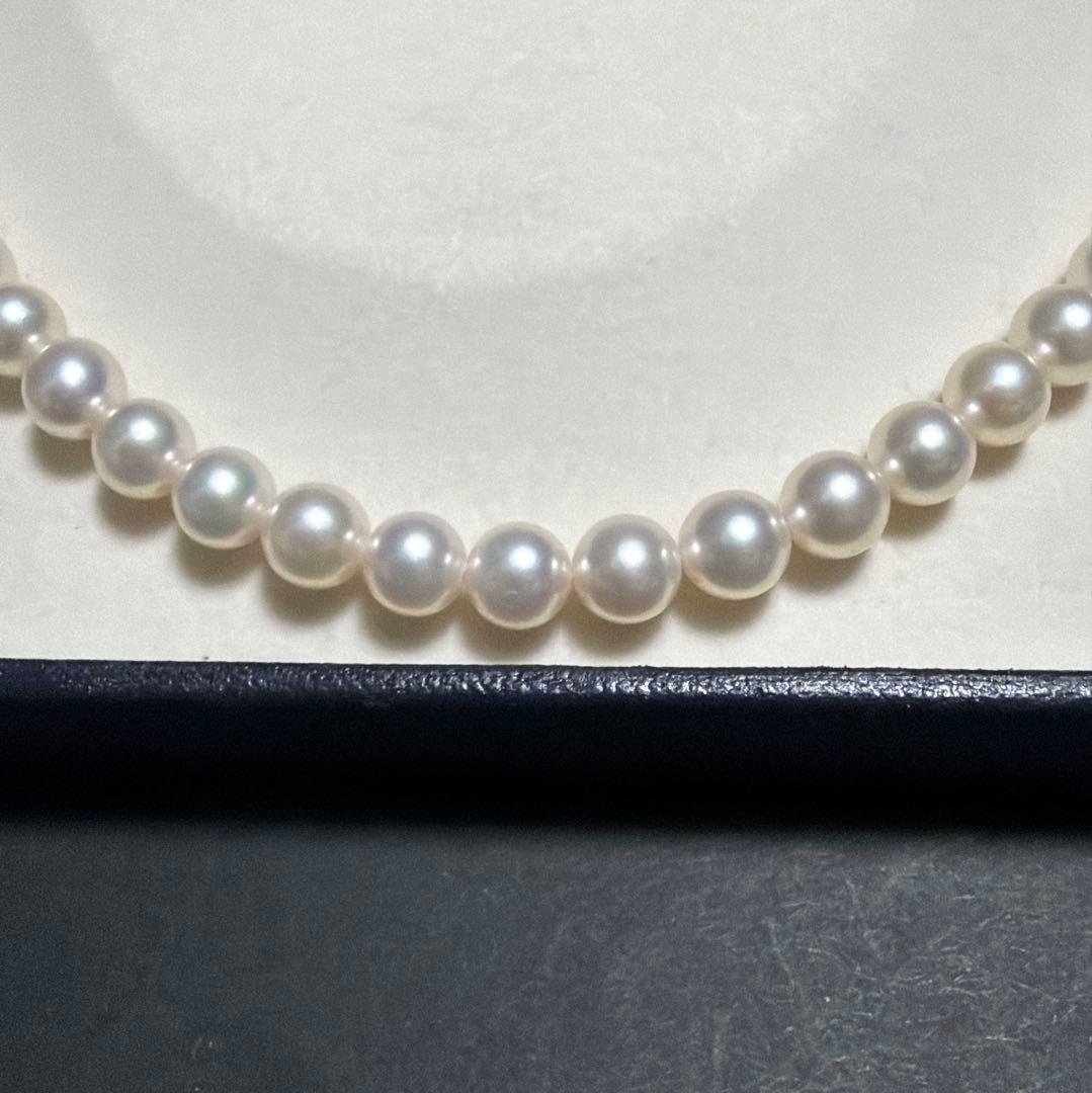 MIKIMOTO Akoya Pearl Necklace with 7.5 natural pearls and high luster on a white background