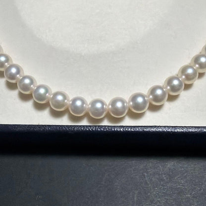 MIKIMOTO Akoya Pearl Necklace with 7.5 natural pearls and high luster on a white background