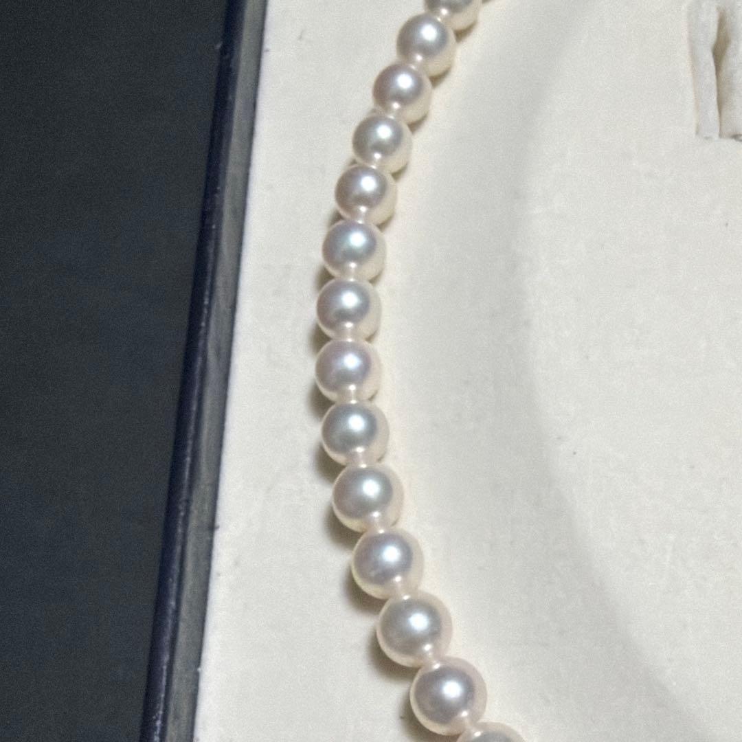 MIKIMOTO Akoya Pearl Necklace with 7.5 natural pearls and high luster on a white background