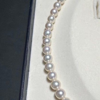 MIKIMOTO Akoya Pearl Necklace with 7.5 natural pearls and high luster on a white background
