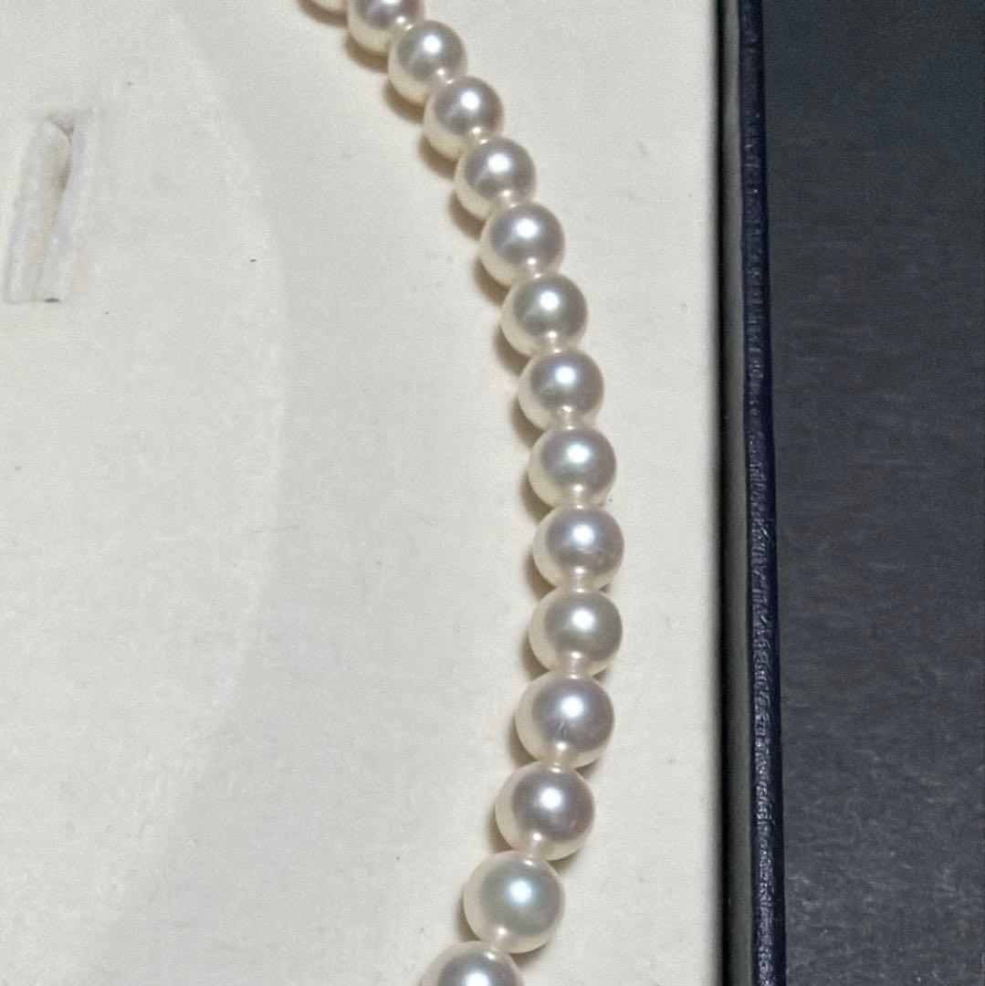 MIKIMOTO Akoya Pearl Necklace with 7.5 natural pearls and high luster on a white background