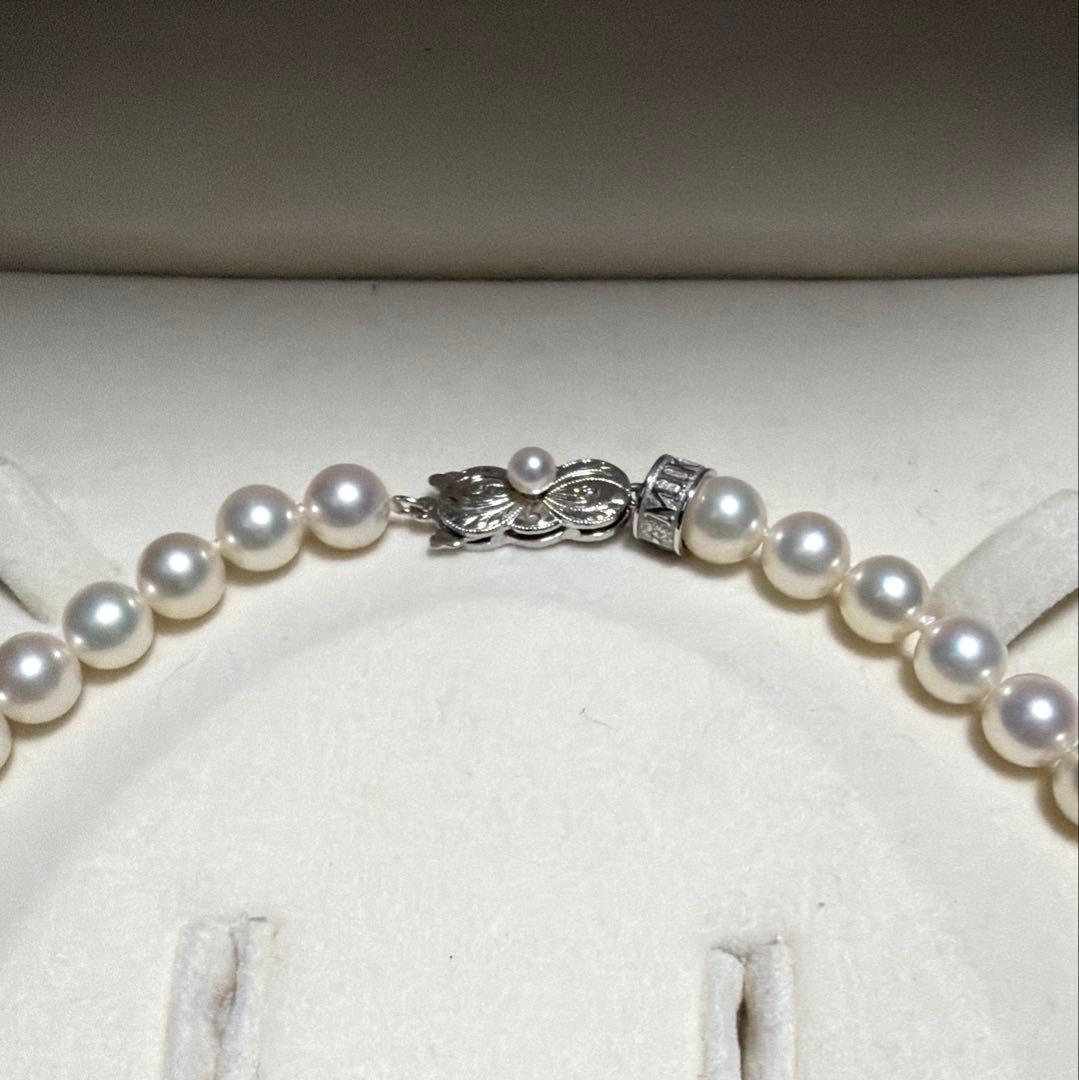 MIKIMOTO Akoya Pearl Necklace with 7.5 natural pearls and high luster on a white background