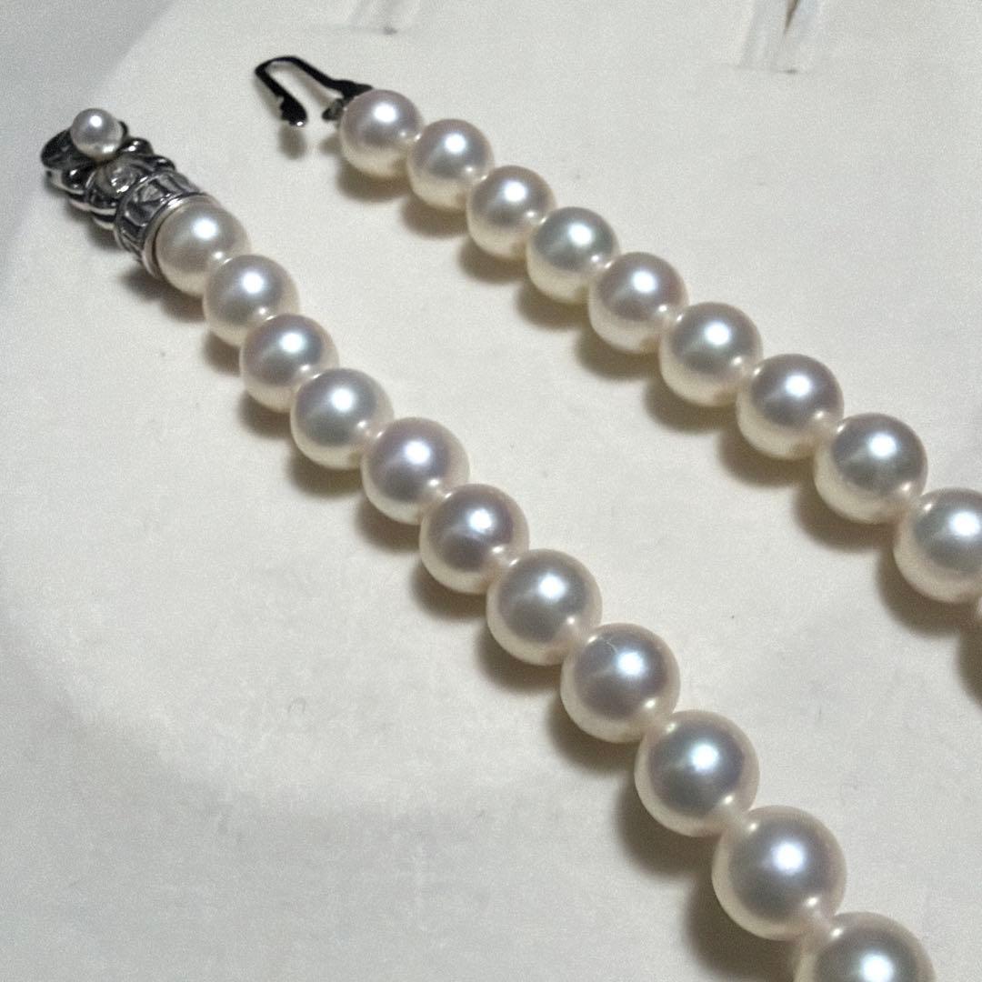 MIKIMOTO Akoya Pearl Necklace with 7.5 natural pearls and high luster on a white background