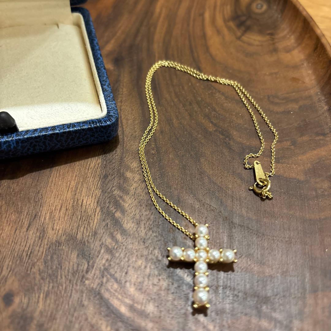 Kuro Cross Cross Shape necklace in K18YG yellow gold with pearl accents on a white background