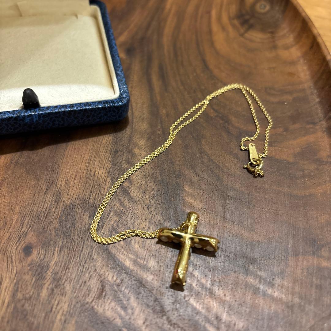 Kuro Cross Cross Shape necklace in K18YG yellow gold with pearl accents on a white background