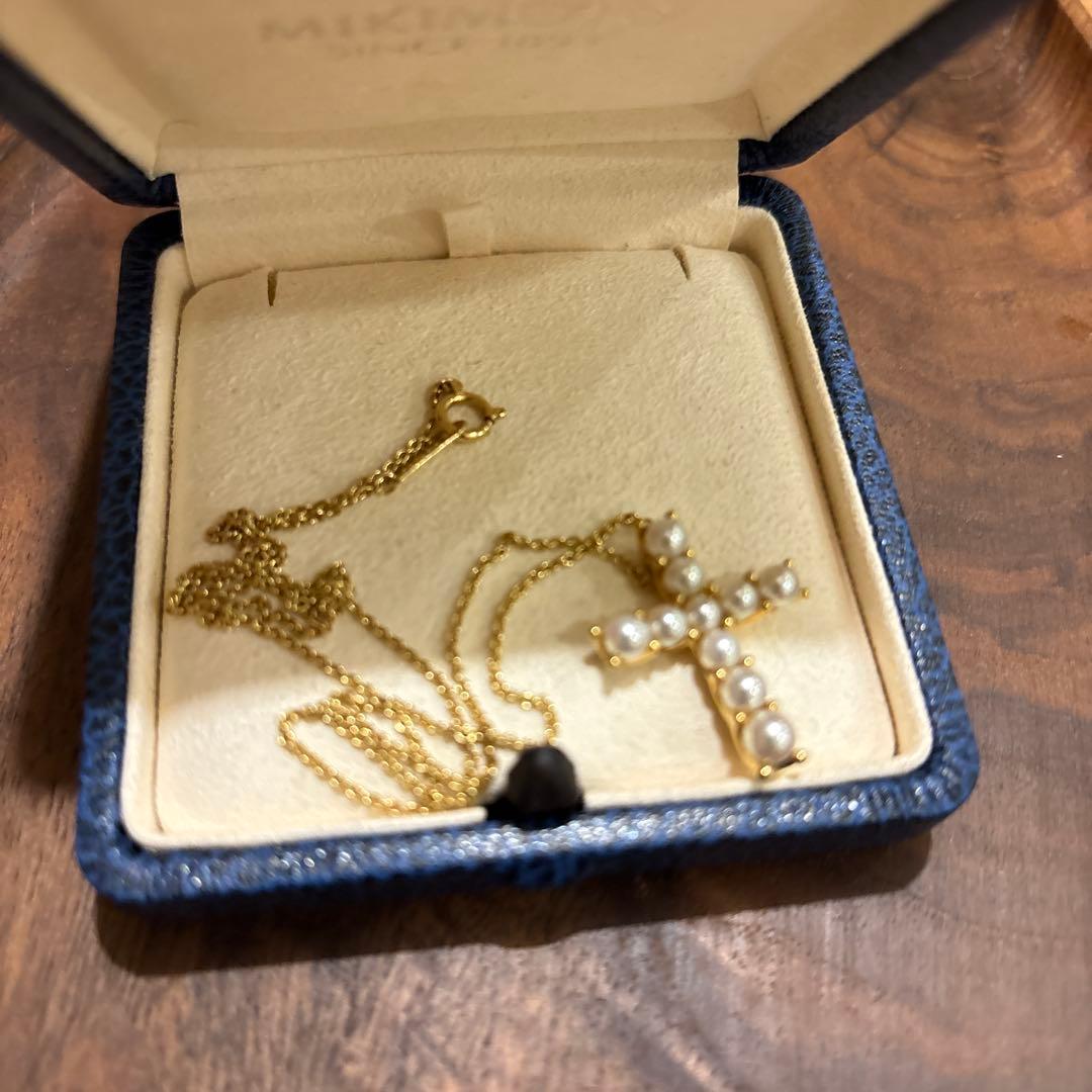 Kuro Cross Cross Shape necklace in K18YG yellow gold with pearl accents on a white background