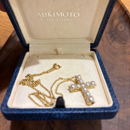 Kuro Cross Cross Shape necklace in K18YG yellow gold with pearl accents on a white background