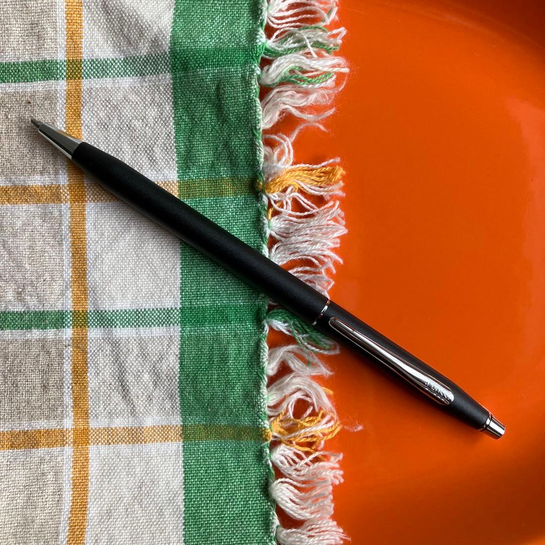 Cross black matte ballpoint pen with silver accents next to Parker blue and black fountain pen with gold nib engraving 88