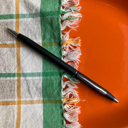 Cross black matte ballpoint pen with silver accents next to Parker blue and black fountain pen with gold nib engraving 88