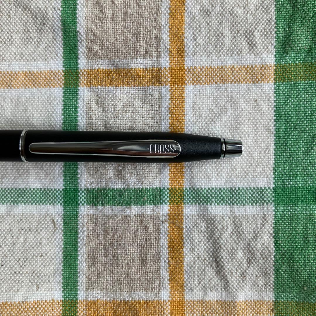 Cross black matte ballpoint pen with silver accents next to Parker blue and black fountain pen with gold nib engraving 88