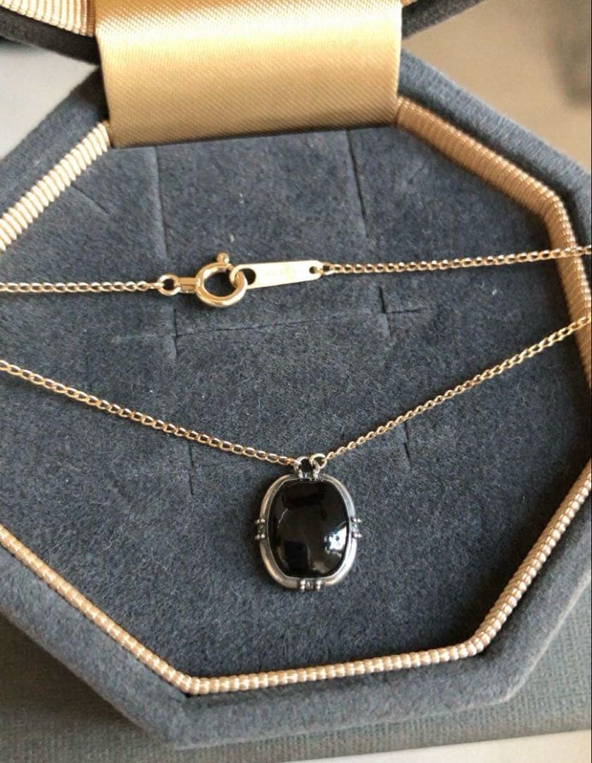 Agete K10 gold and silver necklace with small pendant and adjustable chain laid flat