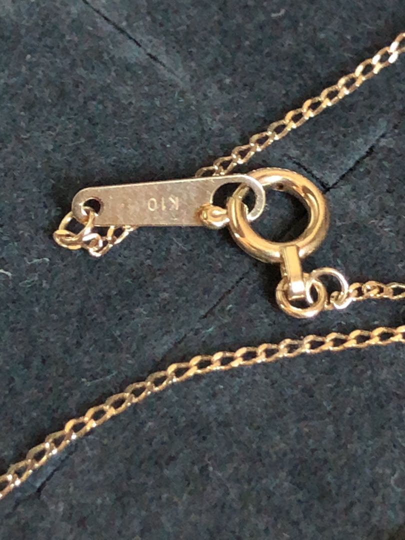 Agete K10 gold and silver necklace with small pendant and adjustable chain laid flat