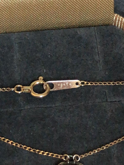 Agete K10 gold and silver necklace with small pendant and adjustable chain laid flat