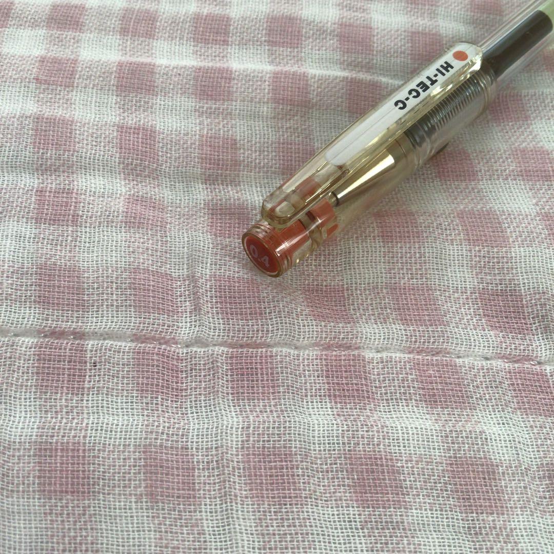 Pilot Hi-Tech C ballpoint pen in fluorescent brown with visible signs of wear and discoloration