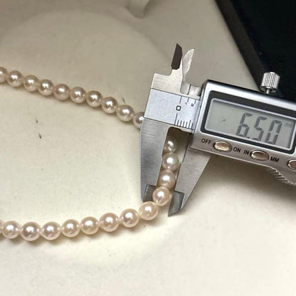 Long 125cm three-strand Akoya pearl necklace with 6.5mm pearls displayed on white background