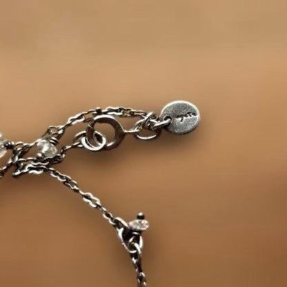 Agete Kuro necklace featuring white beads and metal double chain with slight scratches and discoloration