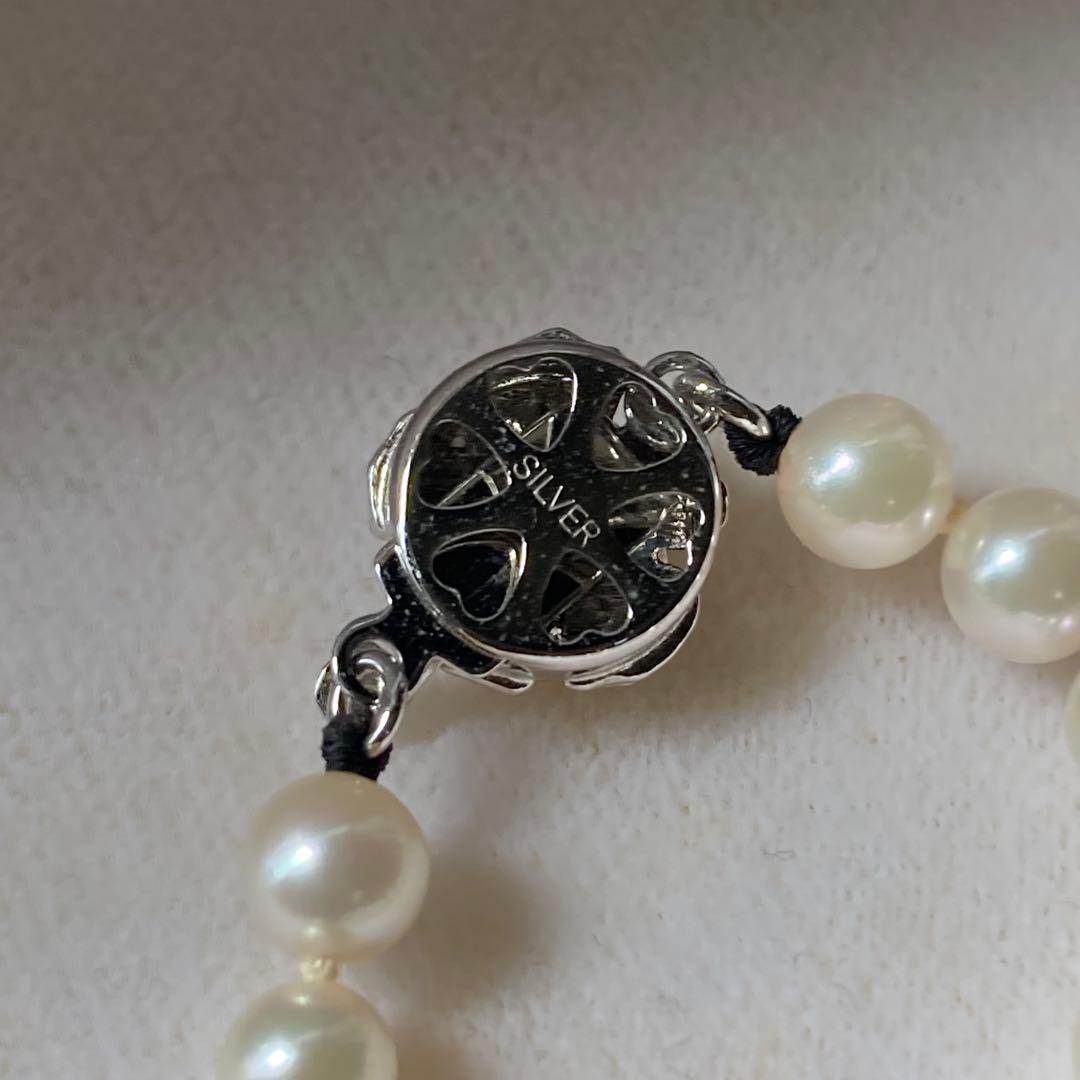 Close-up of Akoya pearl necklace featuring 5mm pearls and a silver clasp with 43.5 cm length