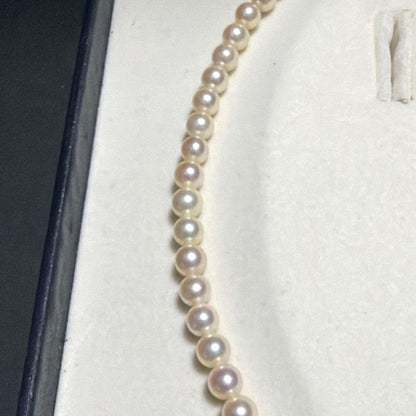 Mikimoto Akoya Pearl Necklace with 5.5mm baby pearls and high luster on a white background