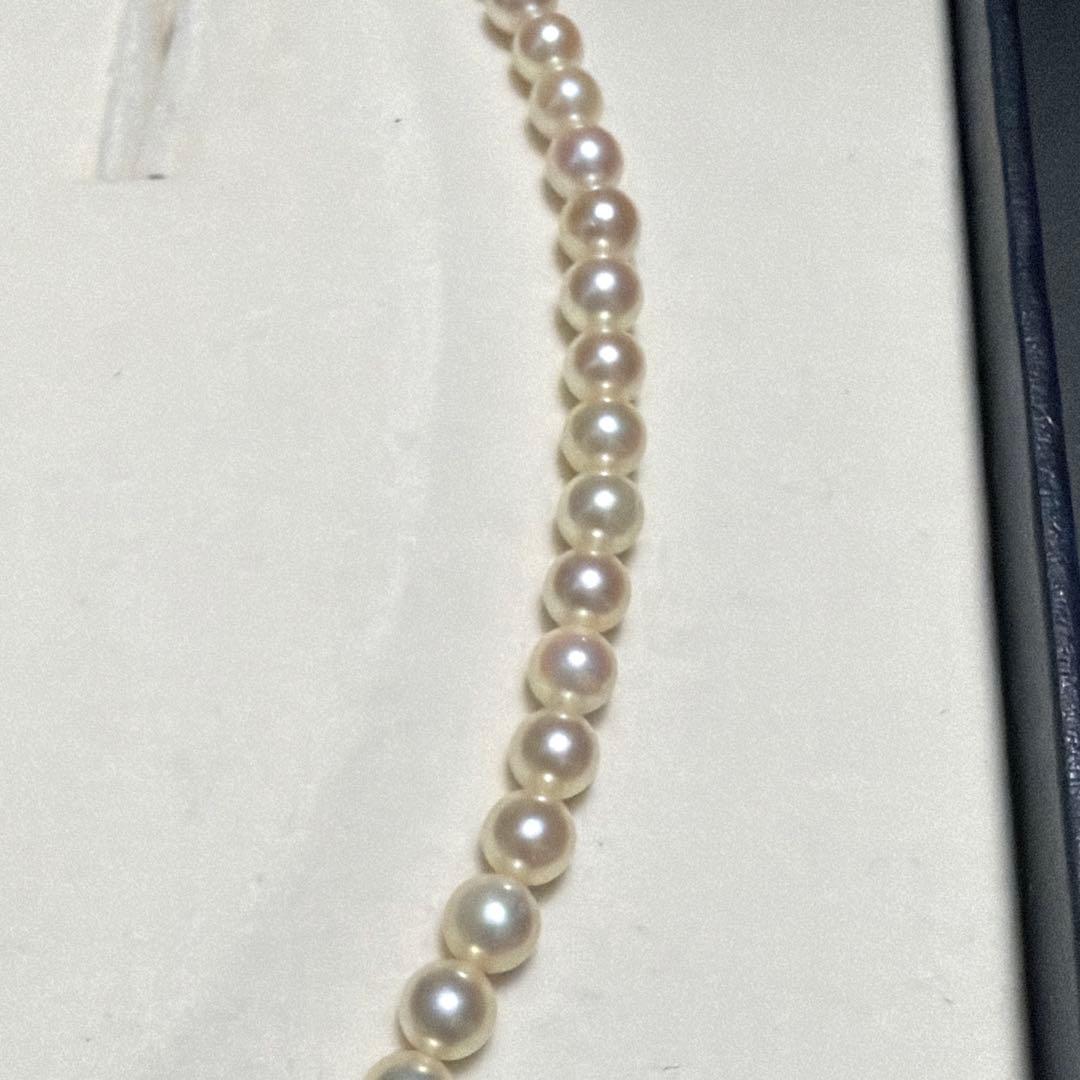 Mikimoto Akoya Pearl Necklace with 5.5mm baby pearls and high luster on a white background