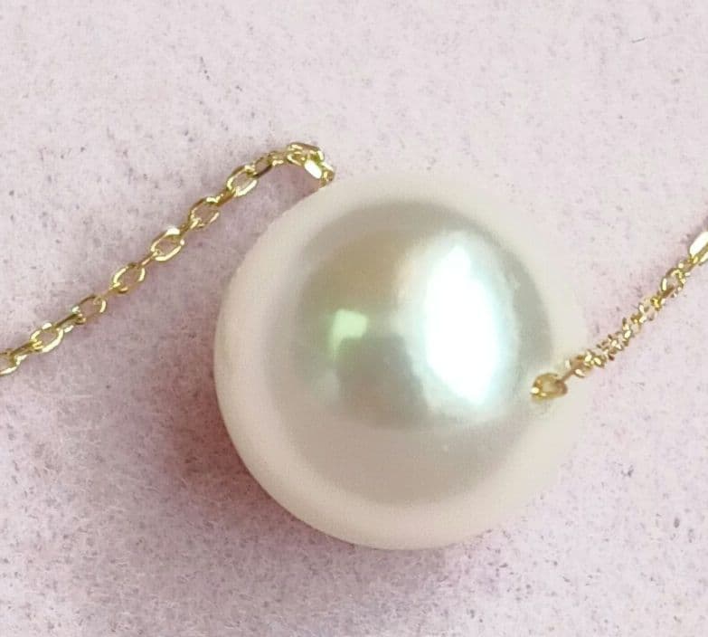 Akoya pearl pendant with 18 karat gold setting and 38cm chain on white background