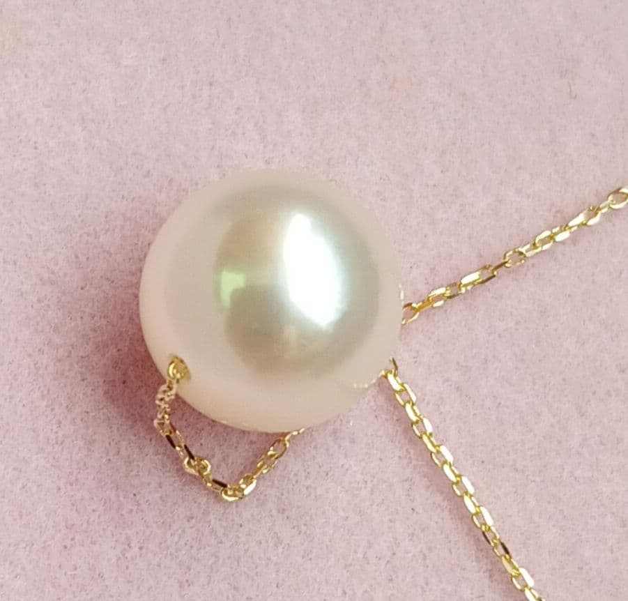 Akoya pearl pendant with 18 karat gold setting and 38cm chain on white background