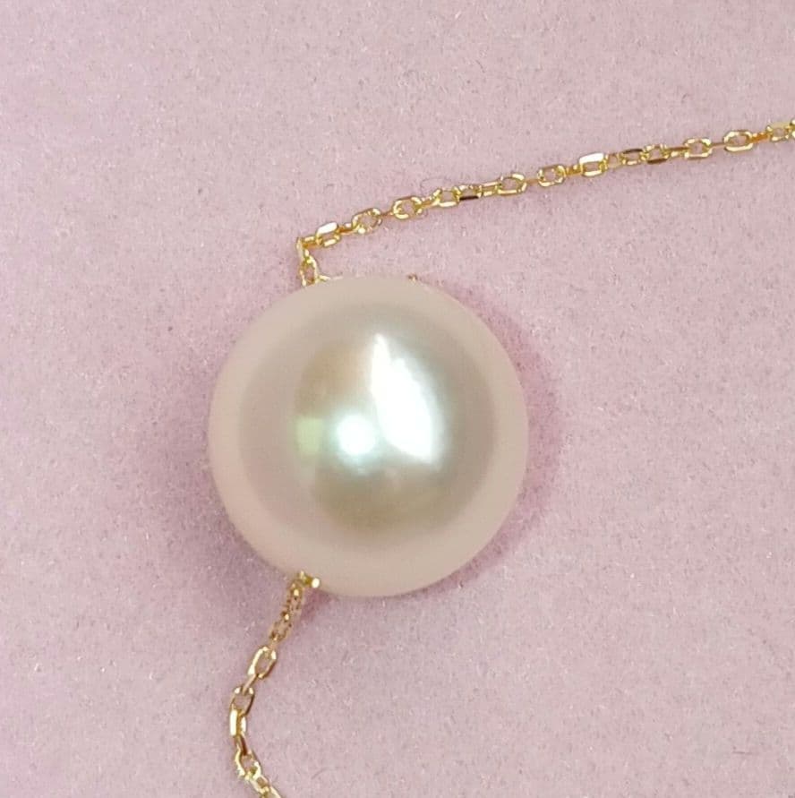 Akoya pearl pendant with 18 karat gold setting and 38cm chain on white background