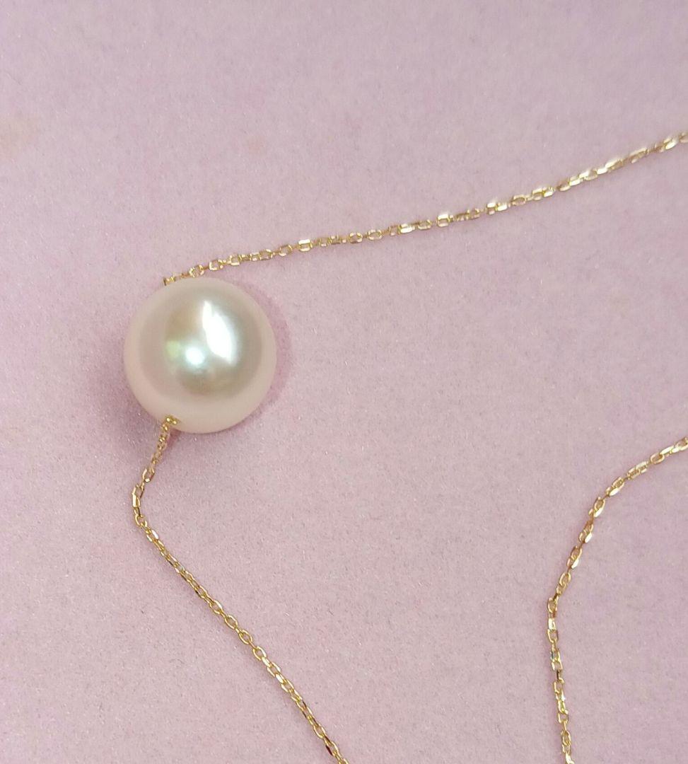 Akoya pearl pendant with 18 karat gold setting and 38cm chain on white background