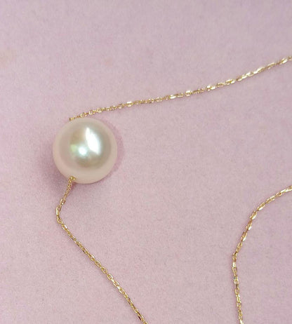 Akoya pearl pendant with 18 karat gold setting and 38cm chain on white background