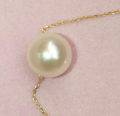 Akoya pearl pendant with 18 karat gold setting and 38cm chain on white background