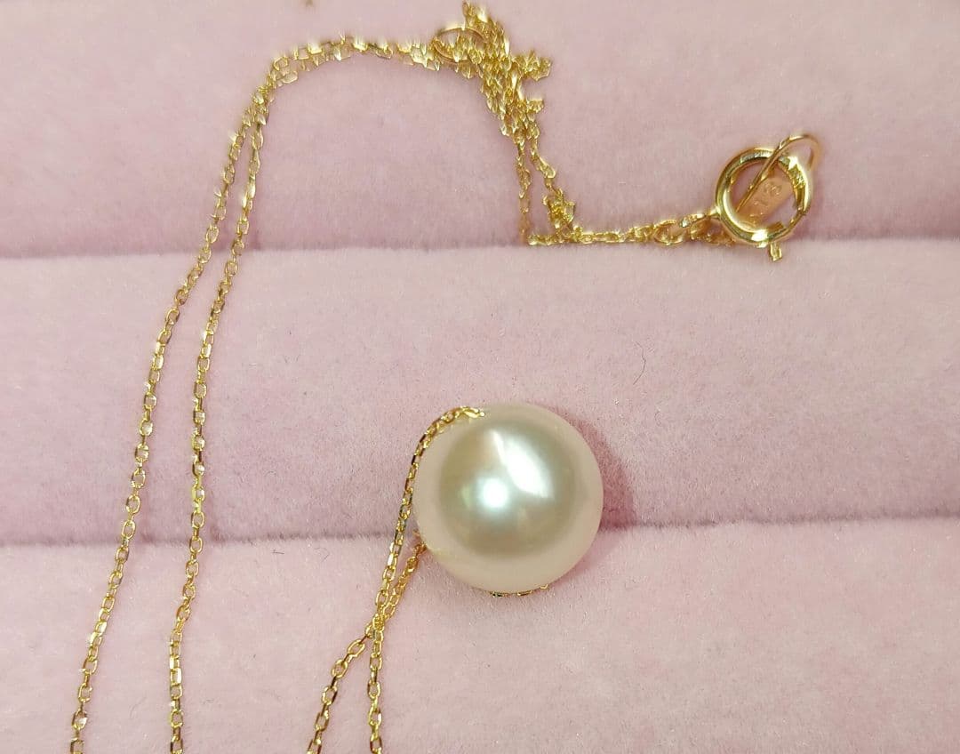 Akoya pearl pendant with 18 karat gold setting and 38cm chain on white background