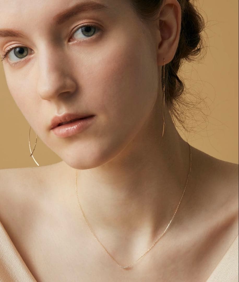 Nika K10 gold necklace with diamond pendant and spring ring clasp on a white background