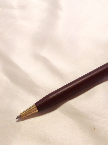 CROSS slim ballpoint pen in chic wine red color writing on paper