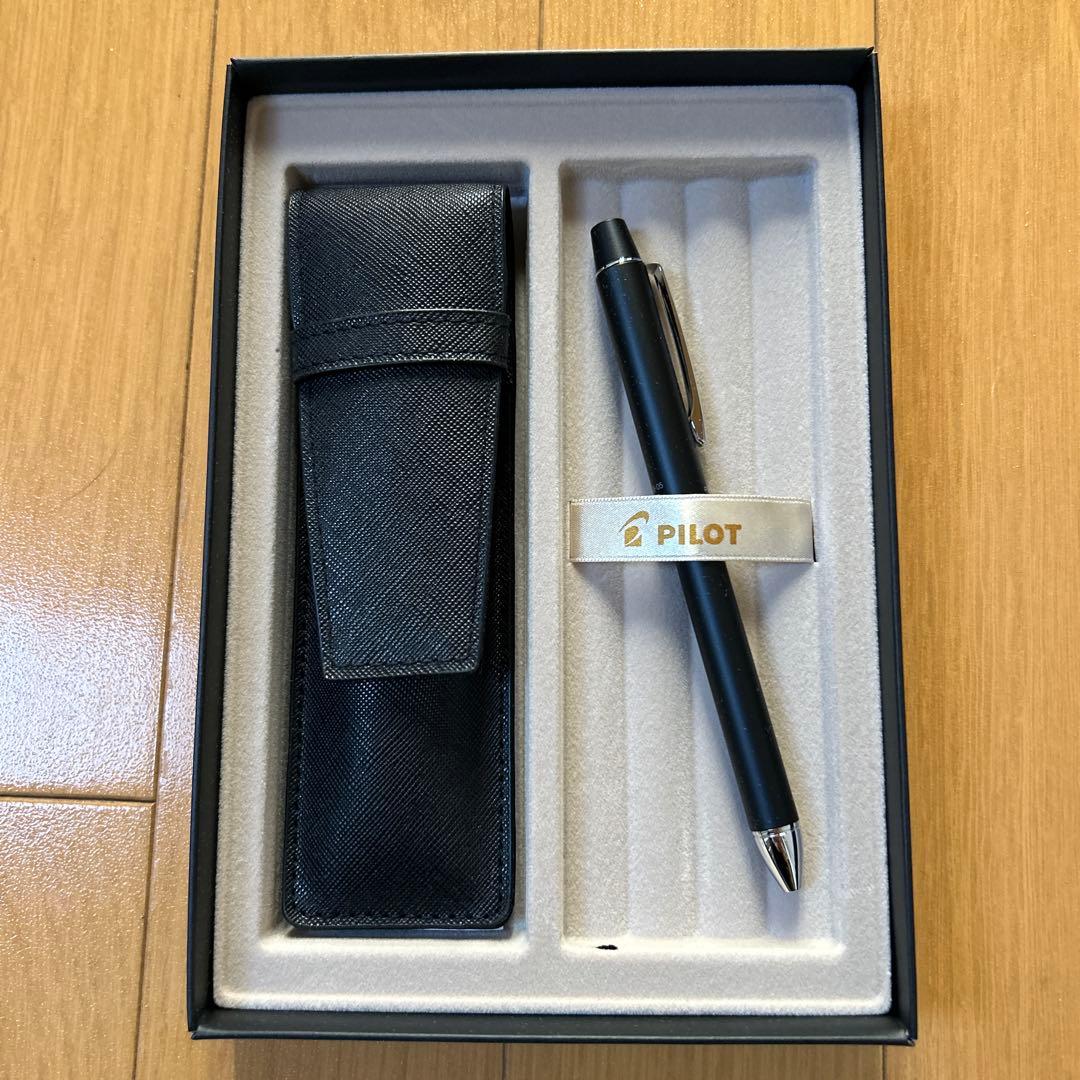 PILOT Z-GR-SBN black ballpoint pen alongside its black pen case with a damaged box