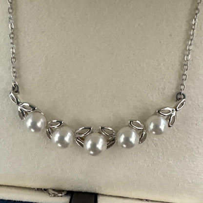 MIKIMOTO Pearl Leaf Motif Necklace featuring pearls and leaf design with chain, displayed with dedicated case