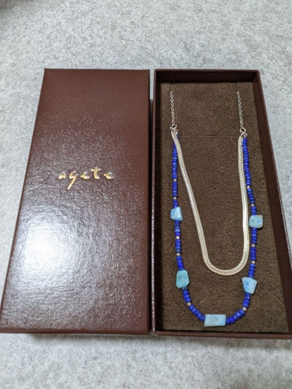 Agete silver double necklace with blue beads featuring a two-strand design, displayed on a white background