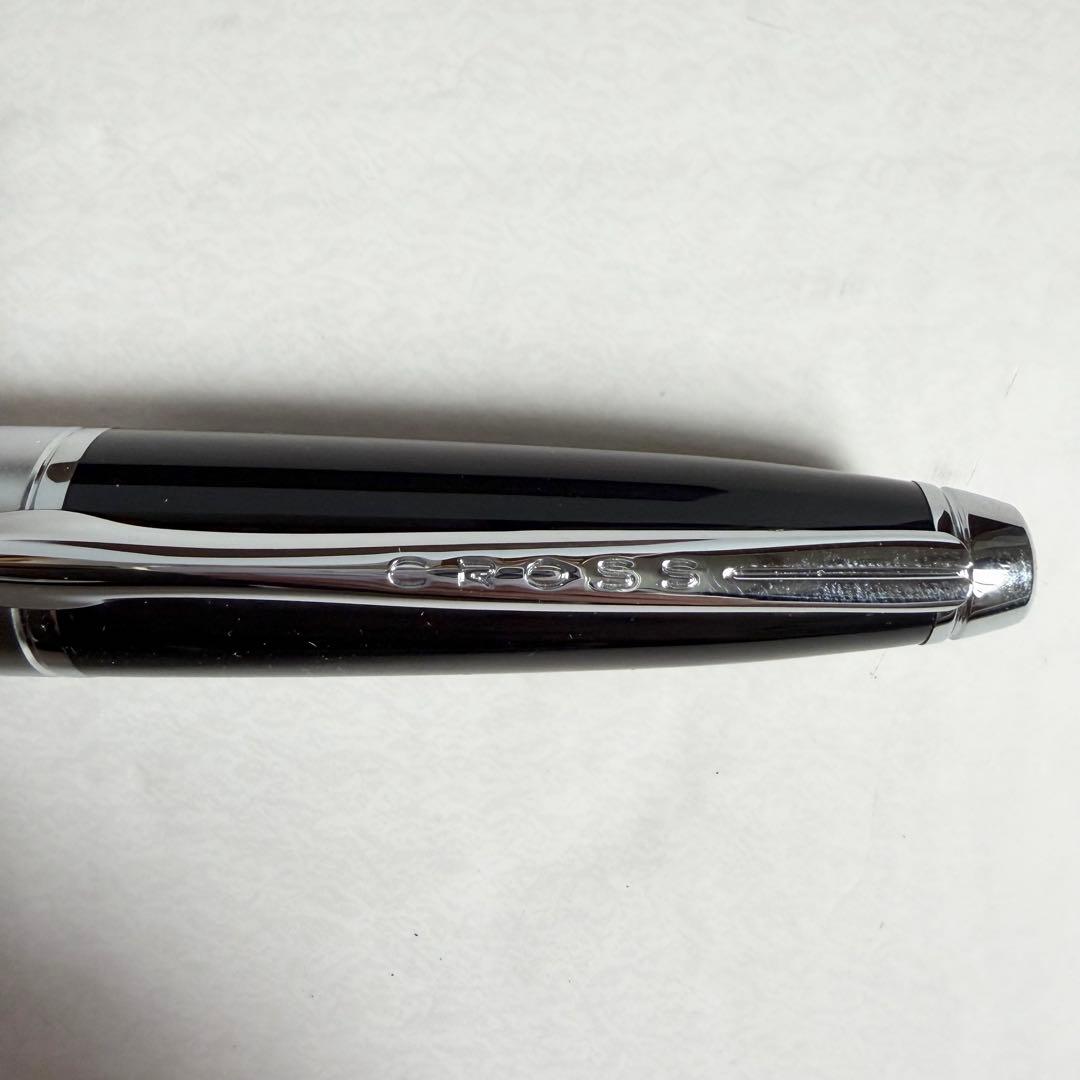 CROSS black ballpoint pen with chrome trim placed beside its dedicated metal case