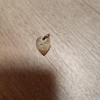 Agete Necklace Charm showing its color change effect with pink and green hues