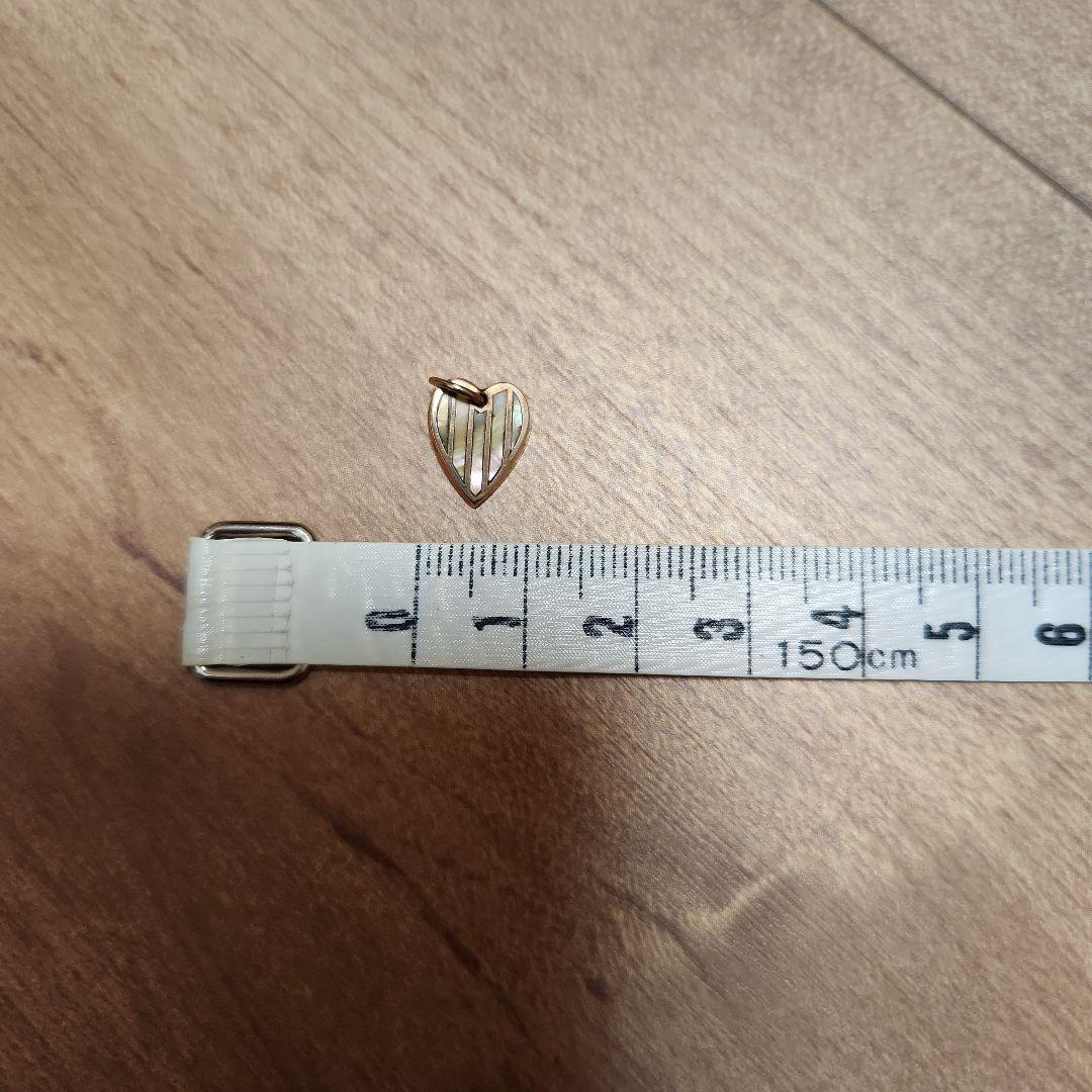 Agete Necklace Charm showing its color change effect with pink and green hues