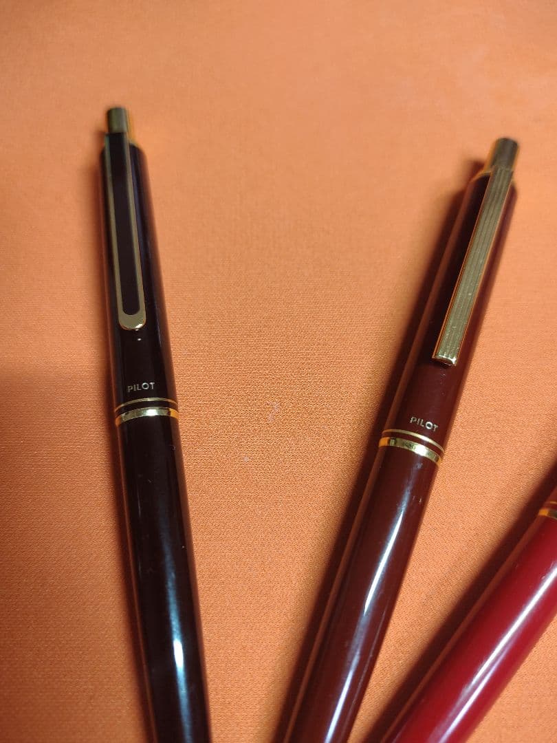Three Pilot mechanical pencils in red and assorted colors, including used and unused items