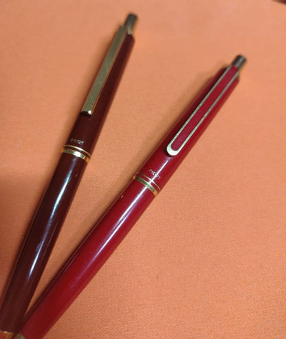Three Pilot mechanical pencils in red and assorted colors, including used and unused items