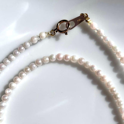 Small K18 Akoya pearl necklace featuring 2.6-3.0mm white pearls with pink and green hues on a 42cm chain