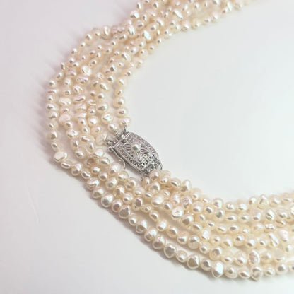 Tasaki Baroque Pearl three-strand necklace about 80cm long displayed on a white background