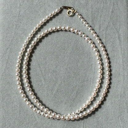K18 Akoya baby pearl necklace with 3.0-3.5mm pearls and 42 cm length on white background