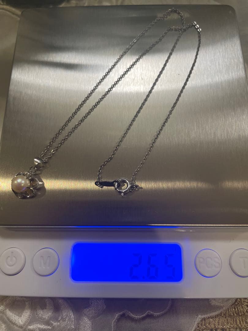 Mikimoto silver pearl necklace with flower motif and 41 cm chain on white background