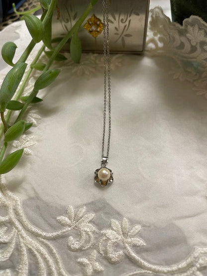 Mikimoto silver pearl necklace with flower motif and 41 cm chain on white background