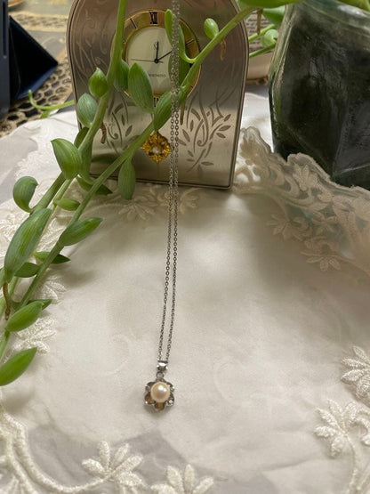 Mikimoto silver pearl necklace with flower motif and 41 cm chain on white background