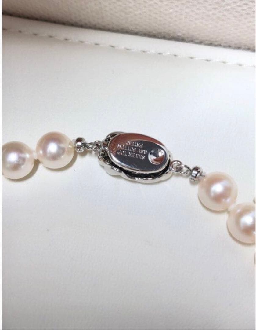 Akoya pearl necklace with 7.5-8mm pearls and matching 8mm silver earrings on white background