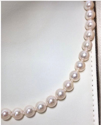 Akoya pearl necklace with 7.5-8mm pearls and matching 8mm silver earrings on white background